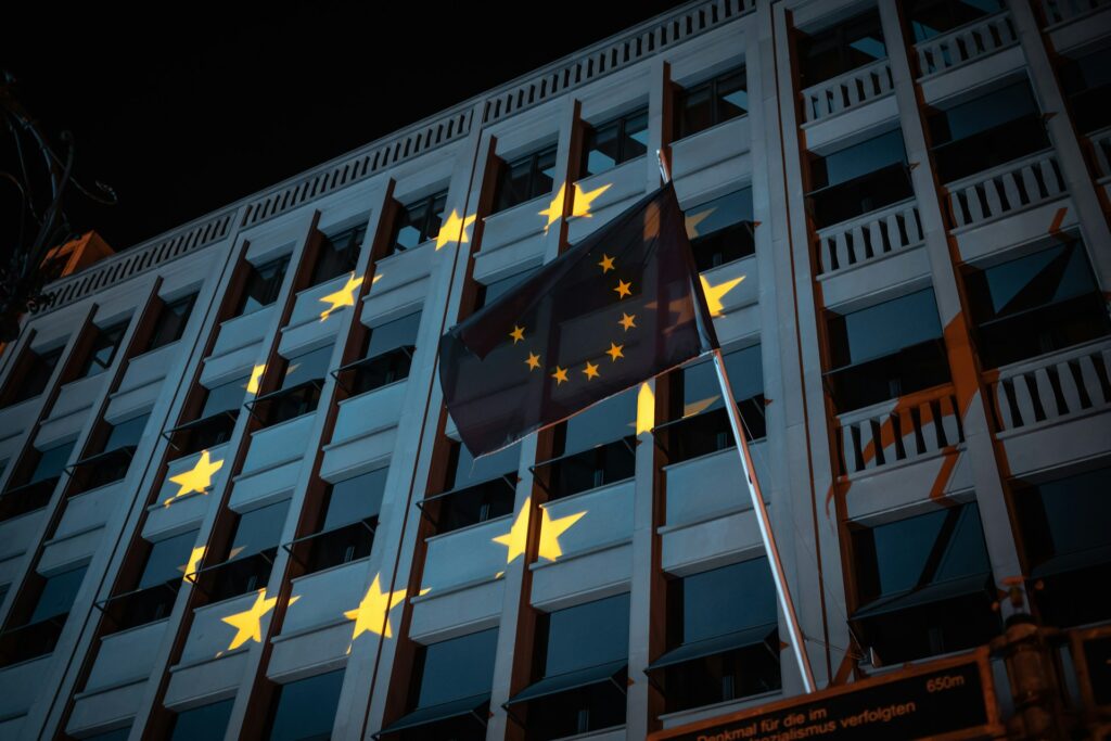 Image of the EU flag in front of a building featuring the projection of a European flag