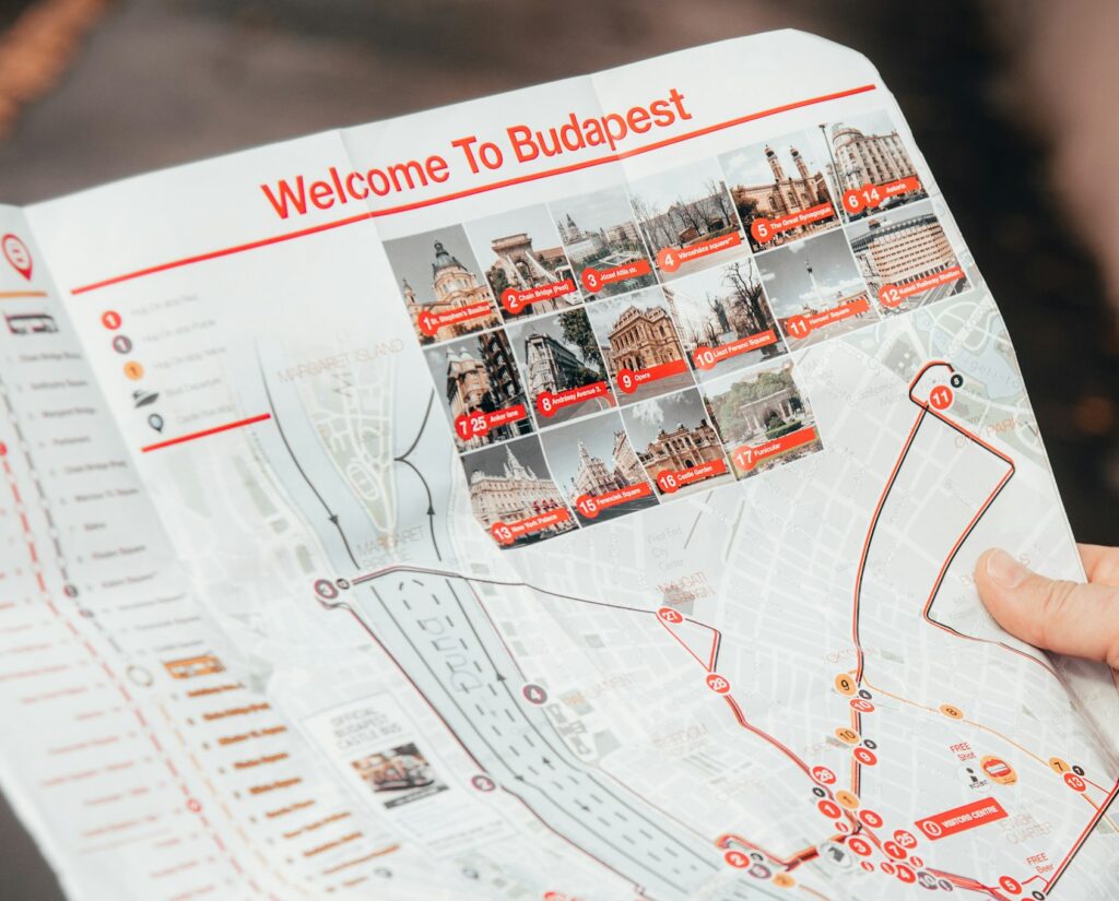 A hand holding a map featuring the main tourist attractions in Budapest