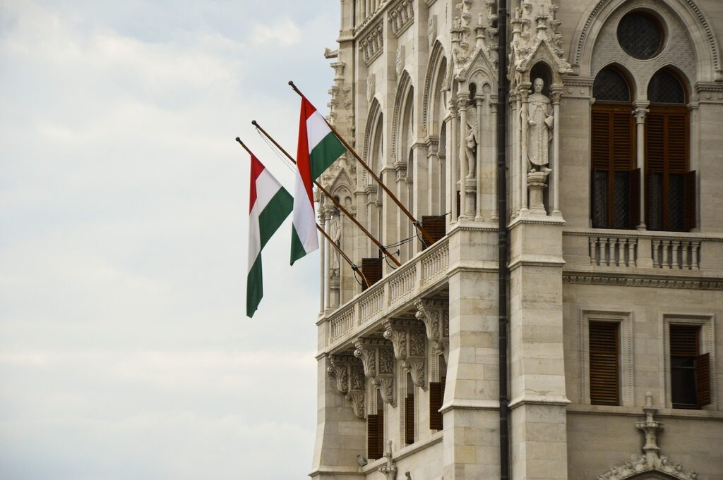 Image of two Hungarian flags hanging from the Parliament in Budapest