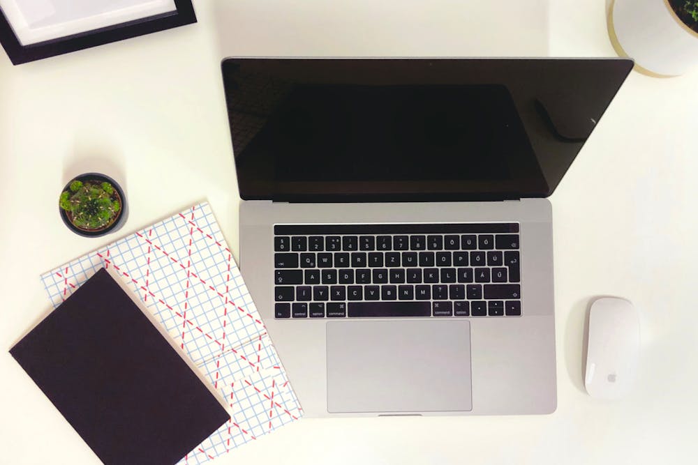 Image of a laptop, mouse and notebook on a desk in a Budapest office in Hungary