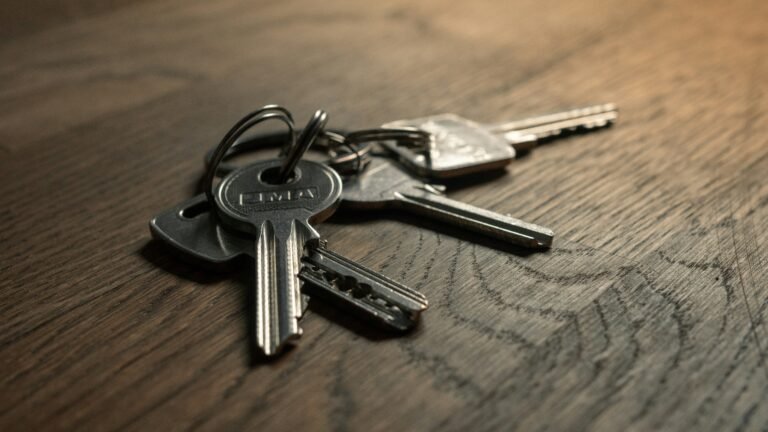 A set of house keys on a wooden table, the symbol of residency by investment as distinct from citizenship by investment